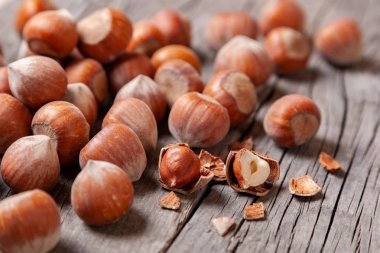 Yığın Hazel ve iki fındık ile eski bir ahşap masa üzerinde kırık deniz hayvanı kabuğu.