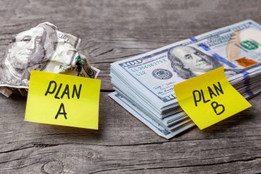 A iş planı ve çukurlu banknot ile dolar yığını B. Office çıkartmaları kar. Ahşap arka plan