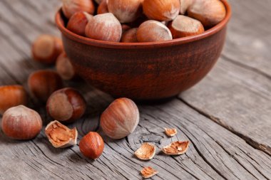 Yığın fındık ve fındık ile eski bir ahşap masa üzerinde kırık deniz hayvanı kabuğu.