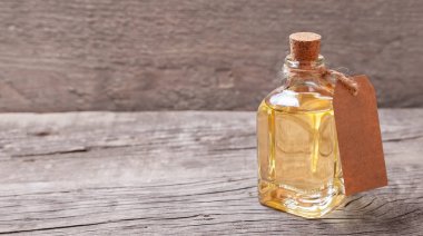 Tereyağı ve ahşap arka plan üzerinde boş etiket ile cam şişe. Metin için yer kopyalayın