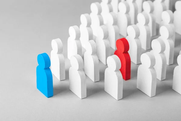 Concept leader of the business team indicates the direction of the movement towards the goal. Crowd of white men goes for the leader of the blue color and  bad conflicting employee of  red color