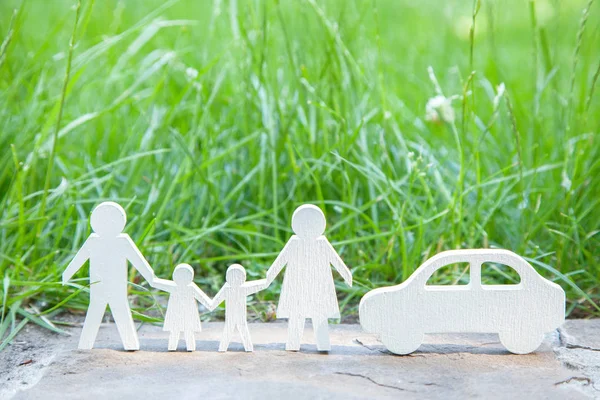 ¿A dónde ir para unas vacaciones en la naturaleza de la familia en coche? Papá, mamá, hijo e hija cerca del coche sobre un fondo de hierba verde — Foto de Stock