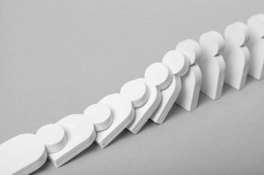 Domino etkisi iş kavramı. Beyaz küçük adamlar birbirlerine düşmek