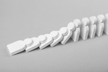 Domino etkisi iş kavramı. Beyaz küçük adamlar birbirlerine düşmek