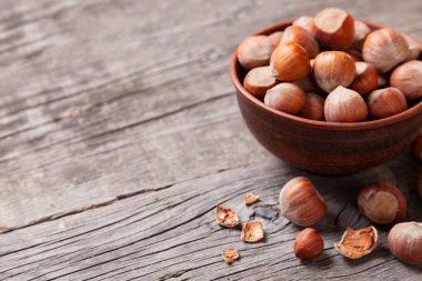 Yığın fındık ve fındık ile eski bir ahşap masa üzerinde kırık deniz hayvanı kabuğu. Metin için yer kopyalayın