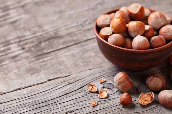 Yığın fındık ve fındık ile eski bir ahşap masa üzerinde kırık deniz hayvanı kabuğu. Metin için yer kopyalayın