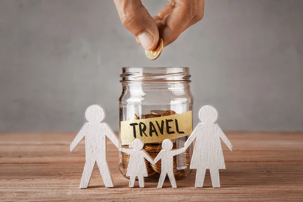 Travel. Glass jar with coins and an inscription is travel and symbol of  family with children. The man holds  coin — Stock Photo, Image