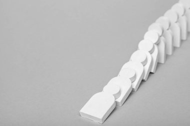 Domino etkisi iş kavramı. Beyaz küçük adamlar her üzerinde düşüş