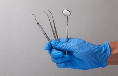 Diş aletleri. Diş Ayna, sonda kanca, gri eldiven Doktor elinde cımbız