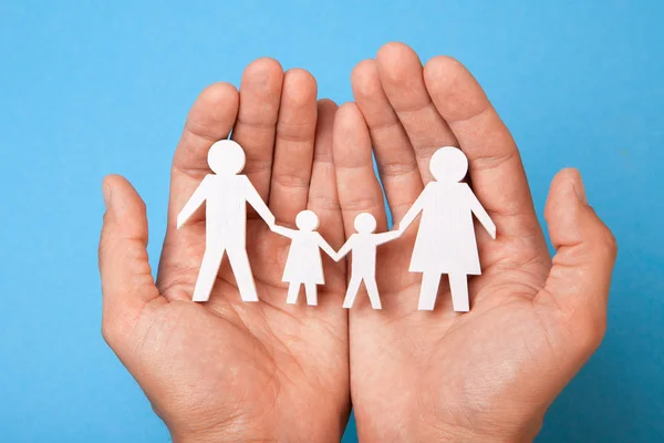 Семейная страховка. Человек держит семью, отца, мать, сына и дочь — стоковое фото