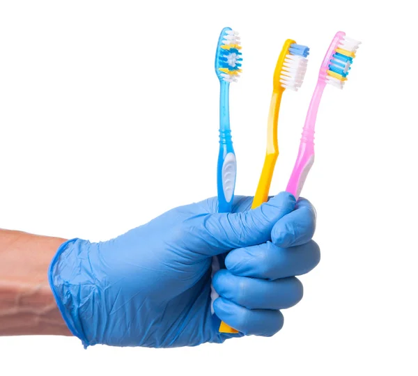 Concept of how to choose the right toothbrush or how to brush your teeth properly. Doctor in blue glove holds toothbrushes — Stock Photo, Image