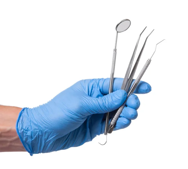 Lékař v modré rukavice drží zubní zrcátka, pinzety, sonda háček v ruce. Izolované na bílém — Stock fotografie