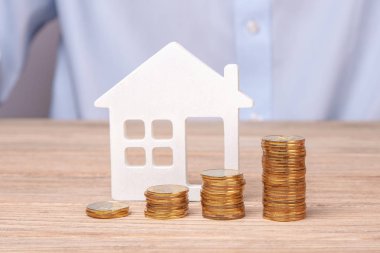 Satış ya da bir ev satın alıyor. Sikke yığını ve evin sembolü