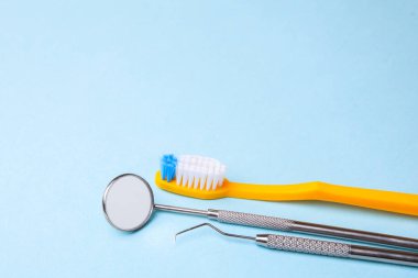 Diş aletleri. Diş Ayna, sonda kanca ve mavi arka plan üzerinde diş fırçası. Kopya alanı