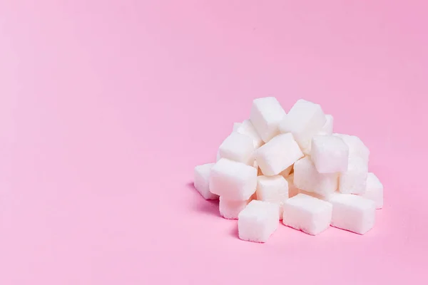 Cubos de açúcar cacho no fundo rosa — Fotografia de Stock