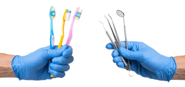 Concept of how to choose the right toothbrush or how to brush your teeth properly. Doctor in blue glove holds dental instruments — Stock Photo, Image