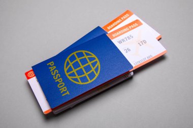 Gri arka plan üzerinde pasaport ile uçak için iki bilet