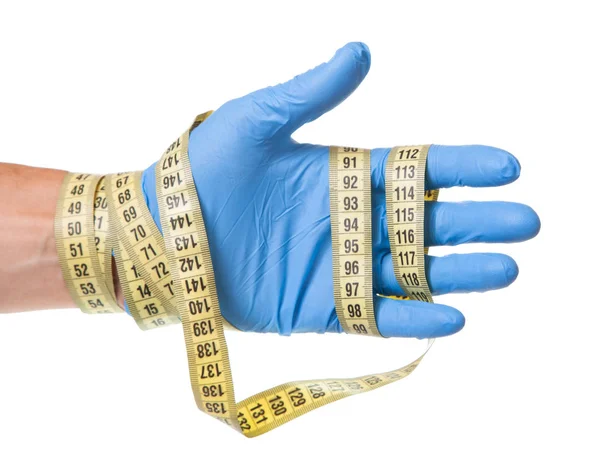 Koncepcja nadwaga, odchudzanie, liposukcja. Lekarz w niebieskie rękawice i taśma pomiarowa w jego rękach jest na białym tle — Zdjęcie stockowe