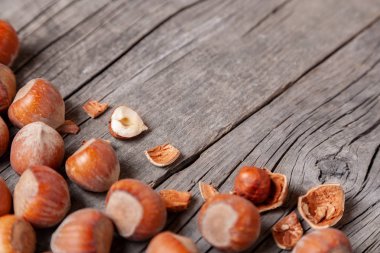 Yığın Hazel ve iki fındık ile eski bir ahşap masa üzerinde kırık deniz hayvanı kabuğu. Kopya alanı