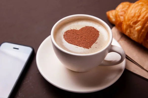 Kalp üzerinde köpük ile kahve fincan. Kahve molası ile kruvasan severim — Stok fotoğraf