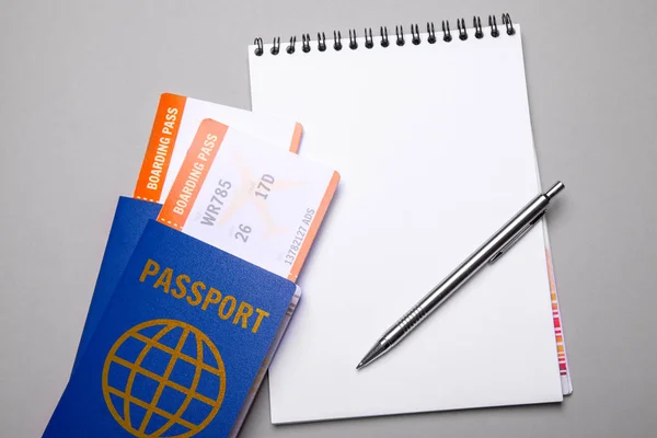 Két jegyet repülőgép útlevelek és szürke tollal a jegyzetfüzet. modell — Stock Fotó