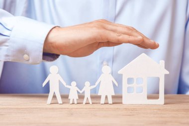 Aile sigortası ve ev. Tişörtlü adam ailesiyle birlikte evi kapsar