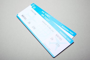 Gri arka plan üzerinde iki uçak biletleri