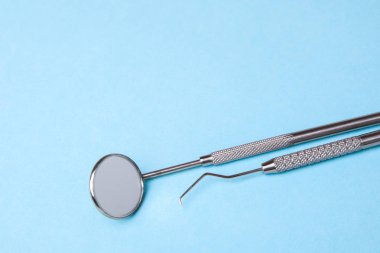Diş aletleri. Mavi arka plan üzerinde diş ayna ve yoklama kanca
