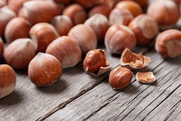 Yığın Hazel ve iki fındık ile eski bir ahşap üzerinde kırık deniz hayvanı kabuğu 