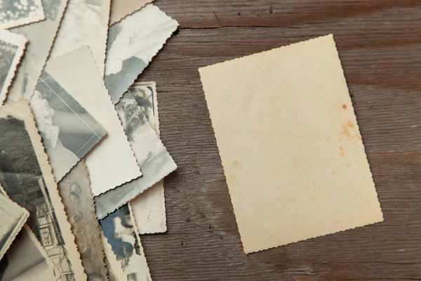 Stapelen van oude foto's op tafel. Mock-up blanco papier. Briefkaart verkreukelde en vuile vintage — Stockfoto