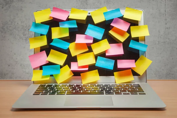 Laptop volledig weergeven in de herinneringen van gekleurde stickers op tafel met grijze muur — Stockfoto