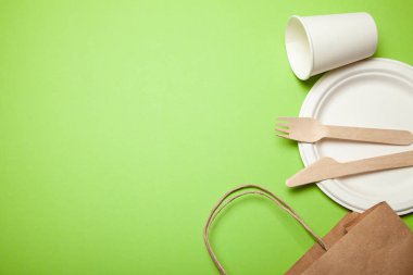 Bambu ahşap ve kağıt üzerinde yeşil çevre dostu tek kullanımlık mutfak eşyaları yapılmış. Kaşık, çatal, bıçak, bol dökümlü kase bardak ve paket ile