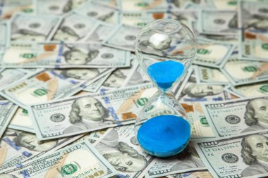 Kum saati ve para dolar banknotlar. Zaman para demektir