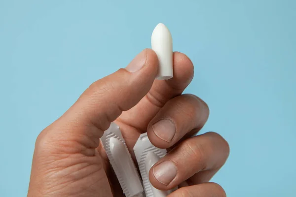 Supositório para uso anal ou vaginal nas mãos de um homem. Velas para tratamento de hemorróidas, temperatura, tordo — Fotografia de Stock