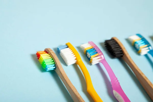 Set di spazzolini da denti su sfondo blu. Concetto selezione spazzolino da denti, bambù eco-friendly e plastica — Foto Stock