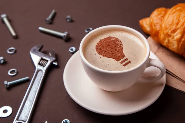 Tazza di caffè con l'idea simbolo di una lampadina sulla schiuma. Il caffè dà nuove idee e creatività. Mattina pausa caffè — Foto Stock