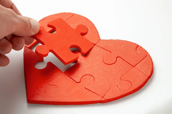 Rompecabezas corazón rojo sobre fondo blanco. Concepto de la segunda mitad del corazón enamorado del Día de San Valentín o enfermedad — Foto de Stock