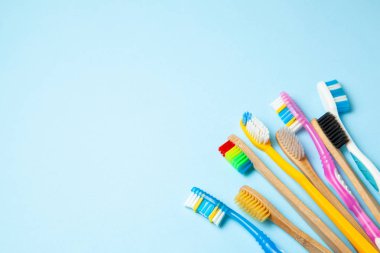 Mavi arka plan üzerinde birçok renkli diş fırçası. Nasıl diş fırçası seçmek için