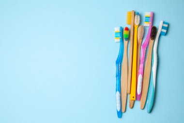 Mavi arka plan üzerinde birçok renkli diş fırçası. Nasıl diş fırçası seçmek için