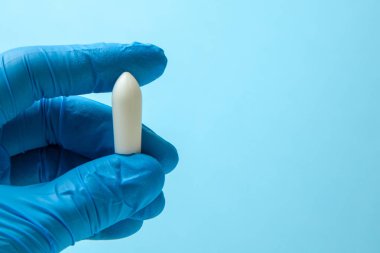 Fitil doktor eldiven elinde anal veya vajinal kullanım için. Hemoroid, sıcaklık, pamukçuk tedavisi için mumlar