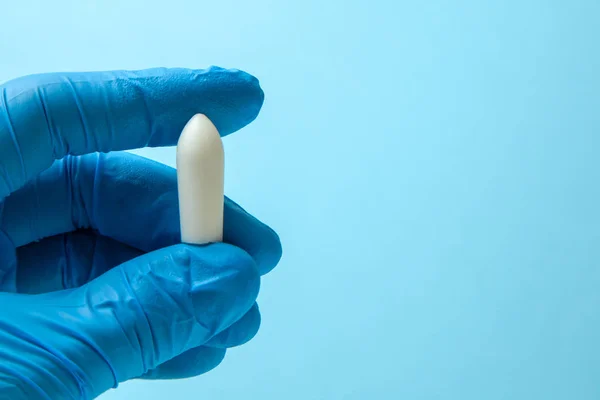 Суппозиторий для анального или вагинального применения в руках врача в перчатках. Свечи для лечения геморроя, температуры, молочницы — стоковое фото