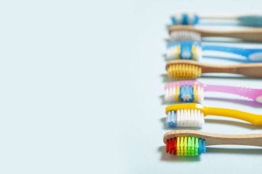 Mavi arka plan üzerinde diş fırçaları kümesini. Kavram diş fırçası seçimi, bambu eco-dostça ve plastik. Metin için yer kopyalayın