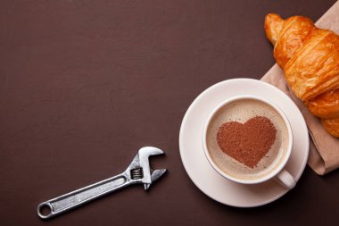 Kalp üzerinde köpük ile kahve fincan. Kahve molası ile kruvasan severim. Onarım hizmet anlayışı. Teknik destek