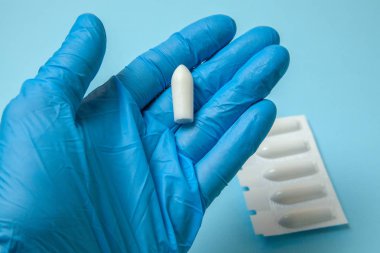 Fitil doktor eldiven elinde anal veya vajinal kullanım için. Hemoroid, sıcaklık, pamukçuk tedavisi için mumlar