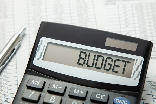 Calculator with the inscription on the BUDGET display on the paper tables. Family budget — Stock Photo, Image