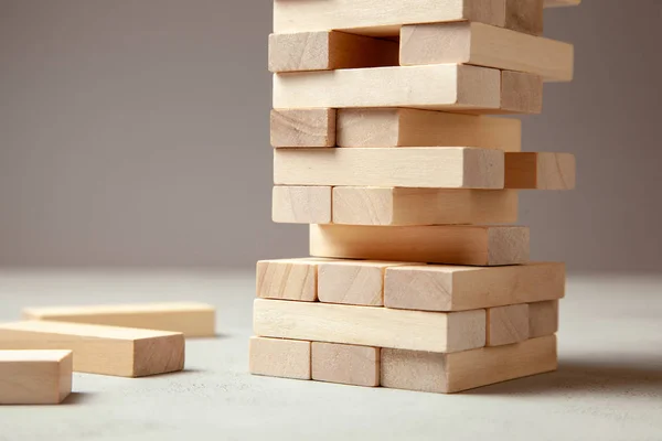 Tower of wooden blocks on gray background. Board game for the whole family or party. Concept of building business or building team