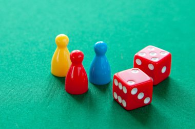 Renkli oyun yongaları masa oyunları için rakamlar. Yeşil tablo üzerinde zar küpleri topluluğu