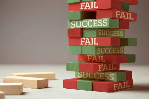 Sucesso e fracasso. Torre de madeira de blocos. O fracasso é como um novo passo para o sucesso. Falha dá experiência e faz você bem sucedido — Fotografia de Stock