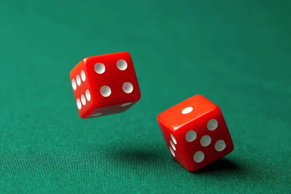 Dos dados rojos en la mesa de juego de poker verde en el casino. Concepto de juego en línea — Foto de Stock