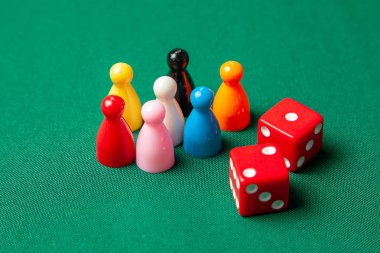 Renkli oyun yongaları masa oyunları için rakamlar. Yeşil tablo üzerinde zar küpleri topluluğu